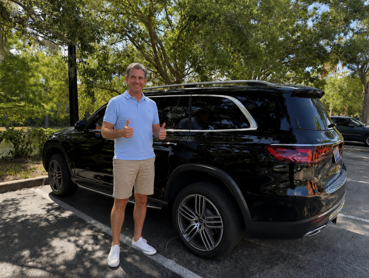 Happy Dents Now customer giving two thumbs up next to his black Mercedes-Benz GLS 450