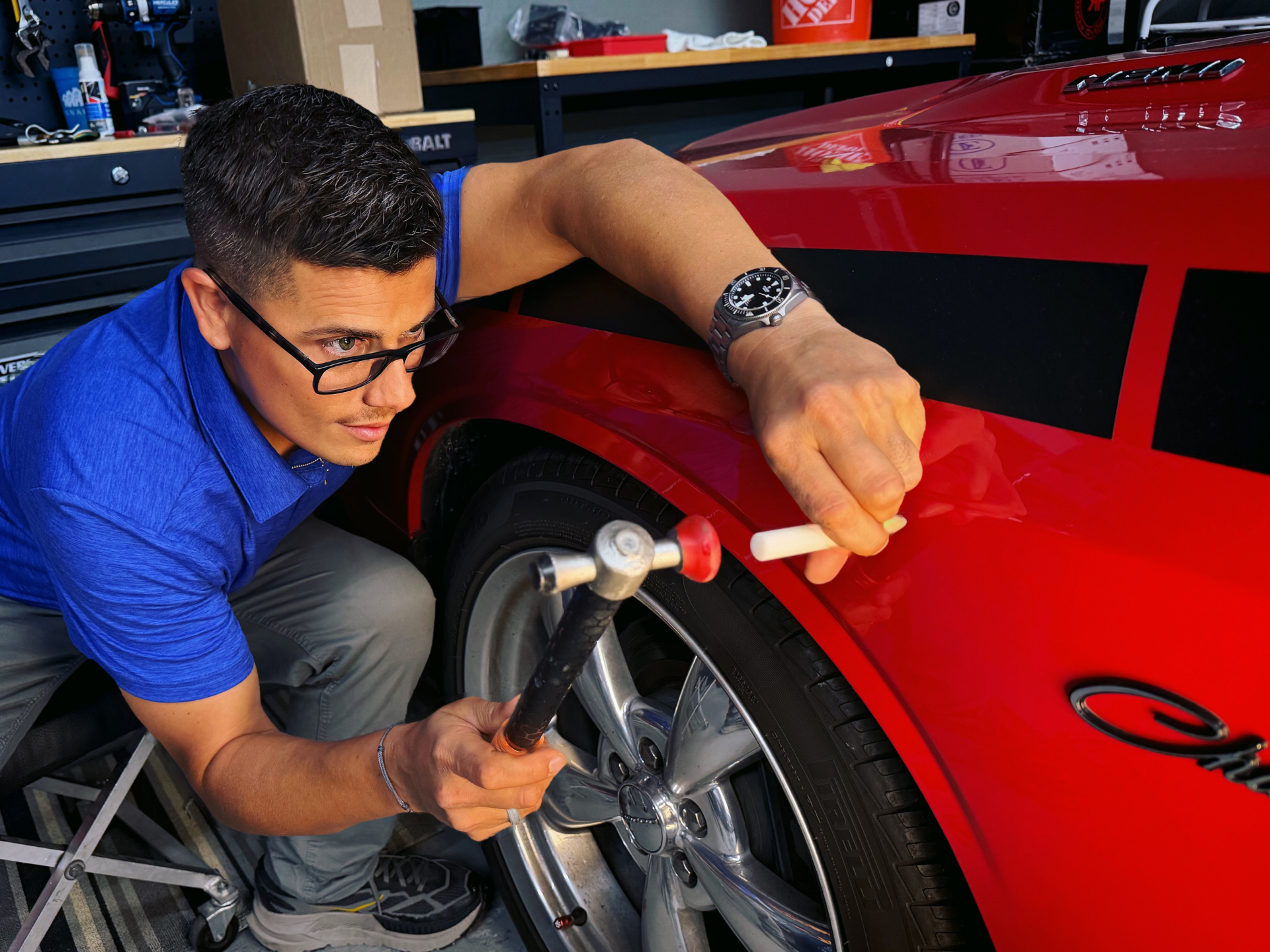 Dents Now technician performing precision paintless dent repair on a red Dodge Challenger fender