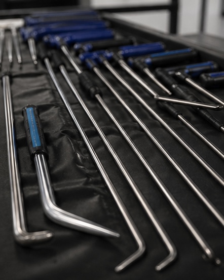 Close-up of professional paintless dent repair rods laid out in the shop