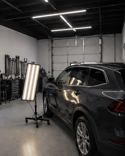 SUV being inspected with a PDR reflection light board inside the Dents Now shop